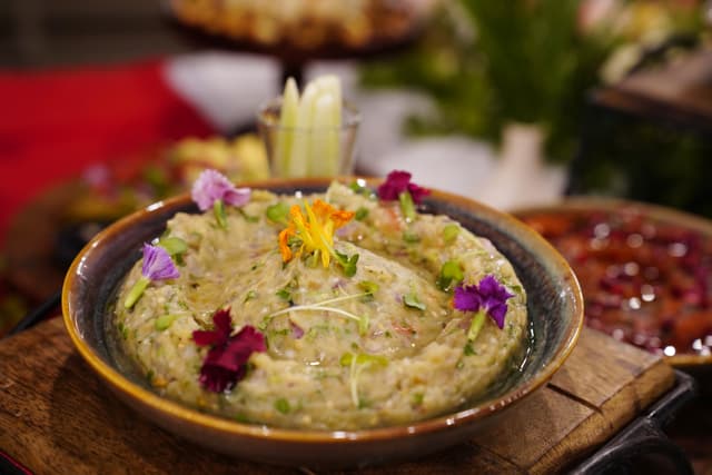 Artisanal eggplant dip garnished with edible flowers served as part of a lavish spread at Saj in the Forest, Pench.