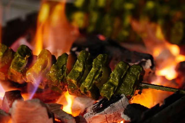 Freshly grilled seekh kebabs over open charcoal fire at Saj in the Forest resort, Pench National Park.