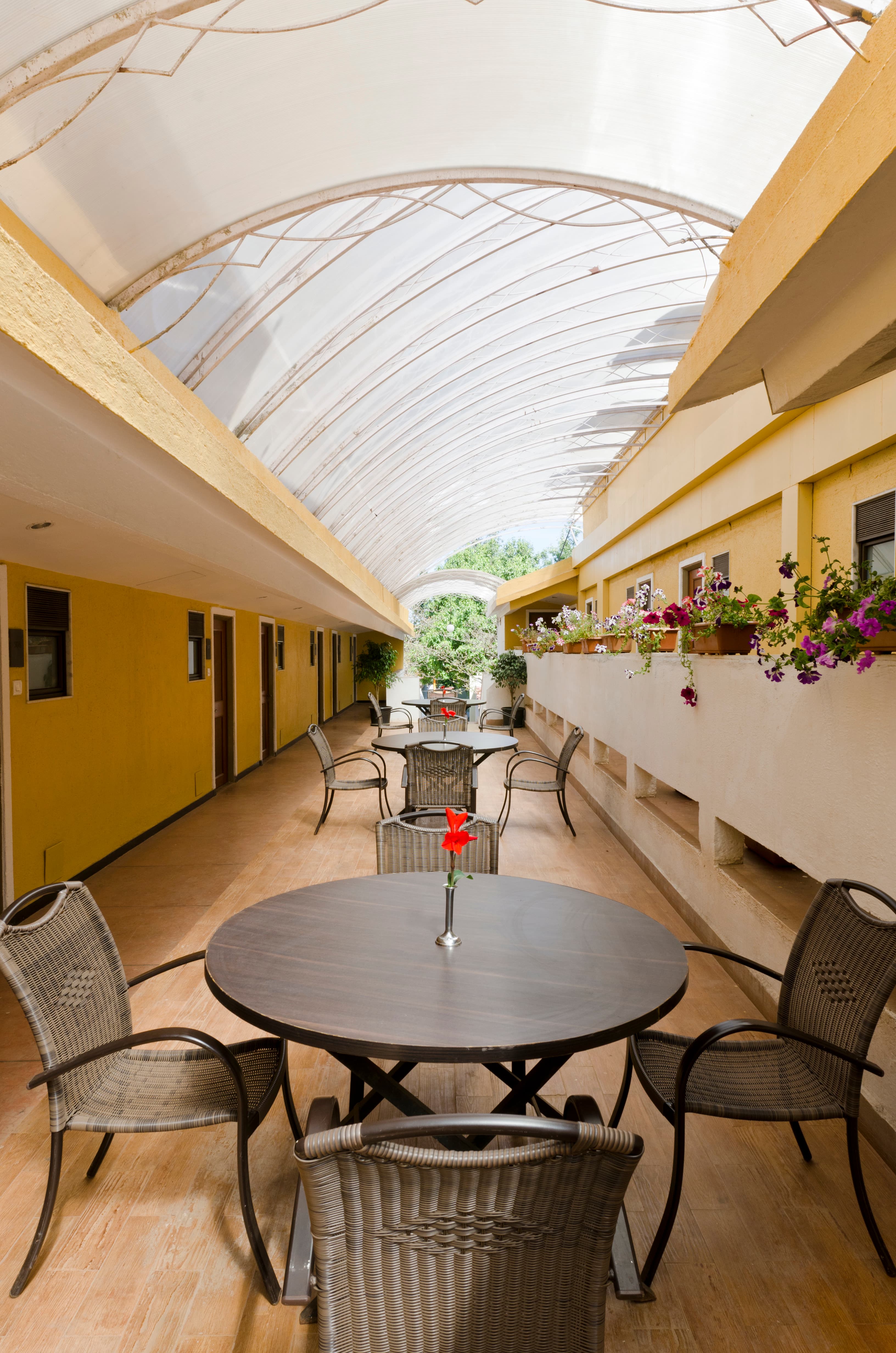 Room corridor at Saj on the Mountain Mahabaleshwar with covered outdoor seating and garden views
