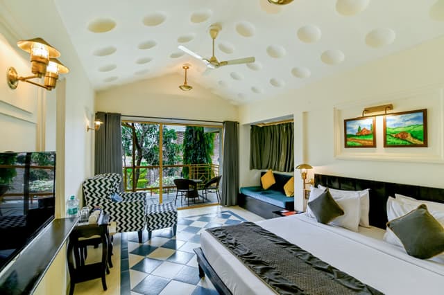 Spacious lake view room at Saj By The Lake with a king bed, chequered floor tiles, unique dotted ceiling and a balcony overlooking the lake.