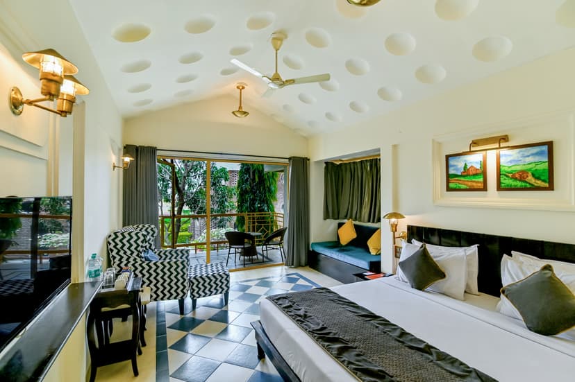 Spacious lake view room at Saj By The Lake with a king bed, chequered floor tiles, unique dotted ceiling and a balcony overlooking the lake.